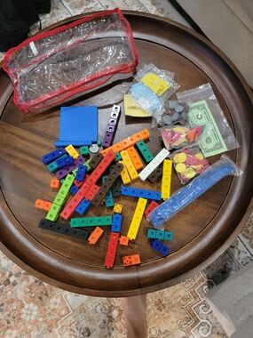 Math manipulatives, including colorful linking cubes and Play Money